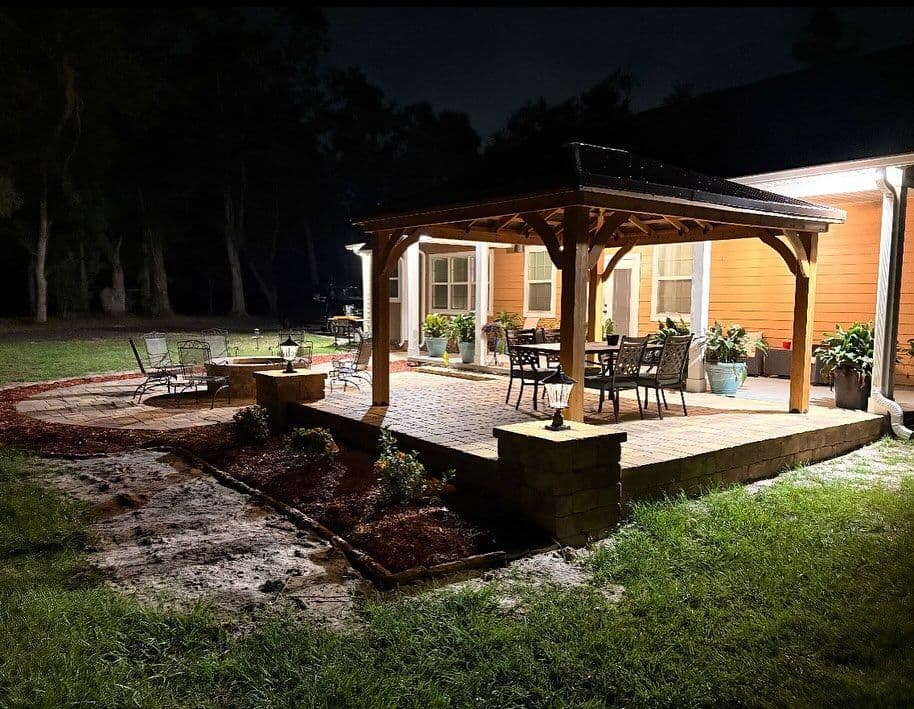 Cozy patio lighting at night with seating and garden features in a serene outdoor setting.